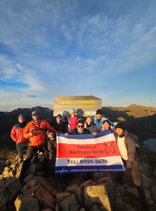 Senderista posando con la bandera en la cumbre del Chirripo, Parque Nacional Chirripo, Costa Rica