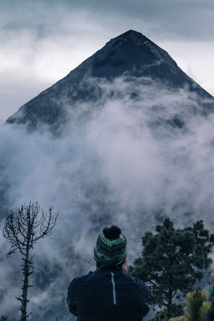 espectador viendo al Volcán de Fuego en un nublado atardecer, Guatemala